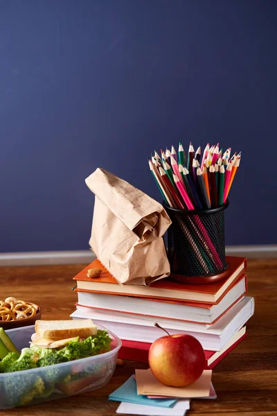 Beyaz masa, seçici odak sağlıklı öğle yemeği kutusu ve okul malzemeleri ile okul öğle yemeği molası kavramı.