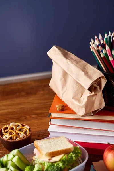 Beyaz masa, seçici odak sağlıklı öğle yemeği kutusu ve okul malzemeleri ile okul öğle yemeği molası kavramı.