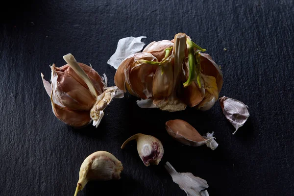 Sarımsak parçaları koyu siyah arka plan üzerine sığ derinliği alan, seçici odak, makro yakın çekim