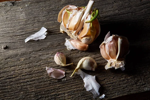 Sarımsak parçalar üzerinde karanlık kesme tahtası ahşap masa, sığ derinliği alan, seçici odak, makro yakın çekim