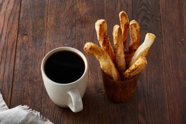 Kahve fincanı ve breadsticks bir eski ahşap arka plan, yakın çekim, seçici odak.