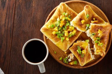 Kahve fincanı, fırından yeni çıkmış meyve pasta ahşap tepsi üzerinde rustik arka plan, yakın çekim, seçici odak üzerinde.