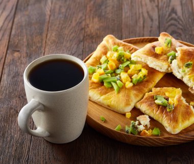 Kahve fincanı, fırından yeni çıkmış meyve pasta ahşap tepsi üzerinde rustik arka plan, yakın çekim, seçici odak üzerinde.