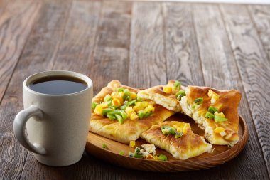 Kahve fincanı, fırından yeni çıkmış meyve pasta ahşap tepsi üzerinde rustik arka plan, yakın çekim, seçici odak üzerinde.