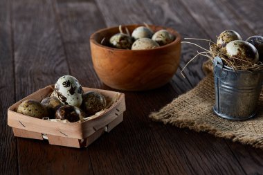 Bıldırcın yumurtası kova, kutu ve ıslak zeminde ahşap arka plan, seçici odak keten bir peçete ile rustik natürmort