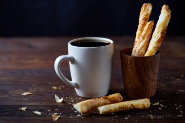 Kahve fincanı, breadsticks ve kruvasan bir eski ahşap arka plan, yakın çekim, seçici odak.