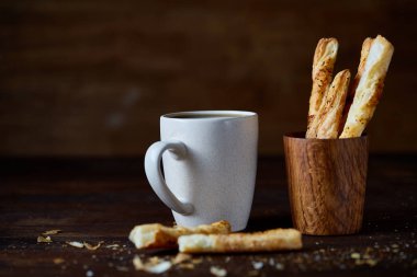 Kahve fincanı, breadsticks ve kruvasan bir eski ahşap arka plan, yakın çekim, seçici odak.