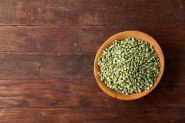 Rustik arka plan, yakın çekim, seçici odak, sığ derinlik-in tarla ahşap bir plaka üzerinde ham yeşil bezelye.