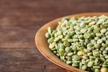 Rustik arka plan, yakın çekim, seçici odak, sığ derinlik-in tarla ahşap bir plaka üzerinde ham yeşil bezelye.