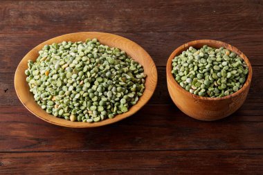 Rustik arka plan, yakın çekim, seçici odak, sığ derinlik-in tarla ahşap bir plaka üzerinde ham yeşil bezelye.