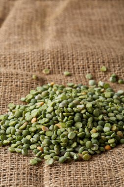 Çuval bezi masa örtüsü, yakın çekim, en iyi görünüm, seçici odak, sığ derinlik-in tarla yeşil bezelye yığını.