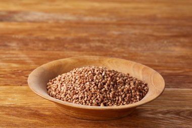 Kase tam buğday tahıl rustik ahşap masa üzerinde yakın çekim, seçici odak, sığ derinlik-in tarla.