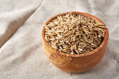 Yulaf kabuğu çıkarılmış tane veya yulaf ani artış ahşap plaka saf masa örtüsü, kopya alanı, üstten görünüm seçici odak üzerinde