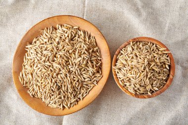 Yulaf kabuğu çıkarılmış tane veya yulaf ani artış ahşap plaka saf masa örtüsü, kopya alanı, üstten görünüm seçici odak üzerinde