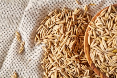 Yulaf kabuğu çıkarılmış tane veya yulaf ani artış ahşap plaka saf masa örtüsü, kopya alanı, üstten görünüm seçici odak üzerinde