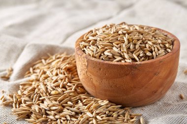 Yulaf kabuğu çıkarılmış tane veya yulaf ani artış ahşap plaka saf masa örtüsü, kopya alanı, üstten görünüm seçici odak üzerinde