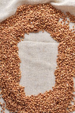 Karabuğday kabuğu çıkarılmış tane çuval bezi arka plan, üstten görünüm, yakın çekim, seçici odak, sığ derinlik-in tarla, dikey.