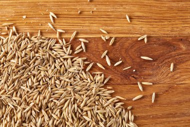 Soyulmamış yulaf taneleri saf masa örtüsü arka plan, üstten görünüm, yakın çekim, makro, seçici odak yığını.