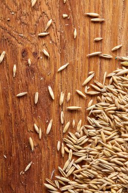 Soyulmamış yulaf taneleri saf masa örtüsü arka plan, üstten görünüm, yakın çekim, makro, seçici odak yığını.