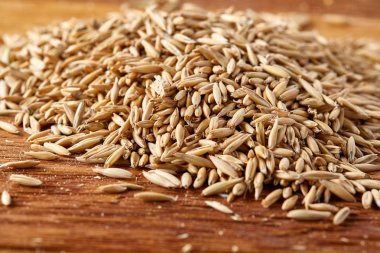 Soyulmamış yulaf taneleri saf masa örtüsü arka plan, üstten görünüm, yakın çekim, makro, seçici odak yığını.