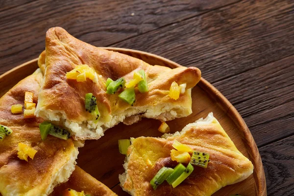 Lezzetli ev yapımı meyve pies düz yatıyordu, yakın çekim, seçici odak rustik ahşap arka plan üzerinde ahşap tepsi