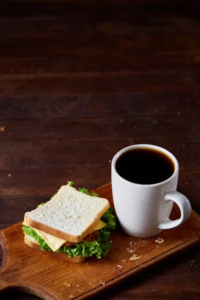 Mesa de desayuno con sándwich y café negro sobre fondo rústico de madera, primer plano, enfoque selectivo — Foto de Stock