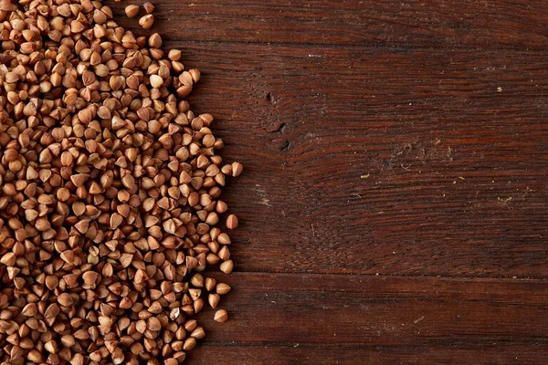 Karabuğday kabuğu çıkarılmış tane ahşap arka plan, üstten görünüm, yakın çekim, seçici odak.