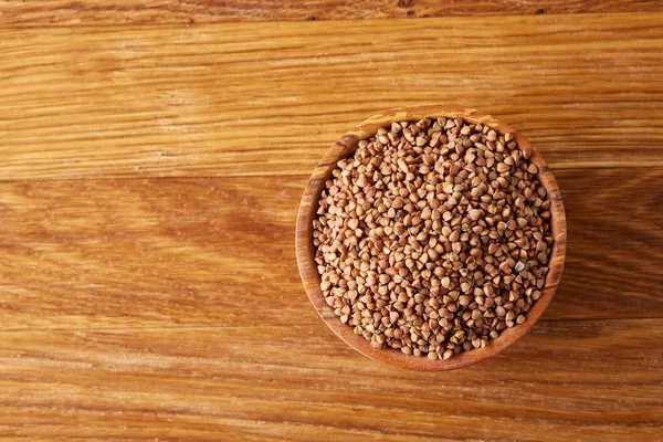 Kase tam buğday tahıl rustik ahşap masa üzerinde yakın çekim, seçici odak, sığ derinlik-in tarla.