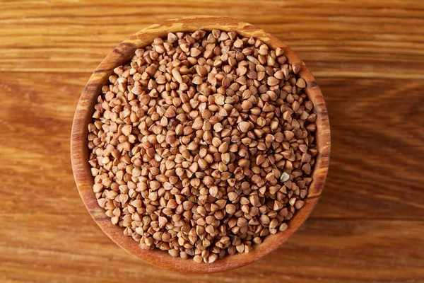 Kase tam buğday tahıl rustik ahşap masa üzerinde yakın çekim, seçici odak, sığ derinlik-in tarla.