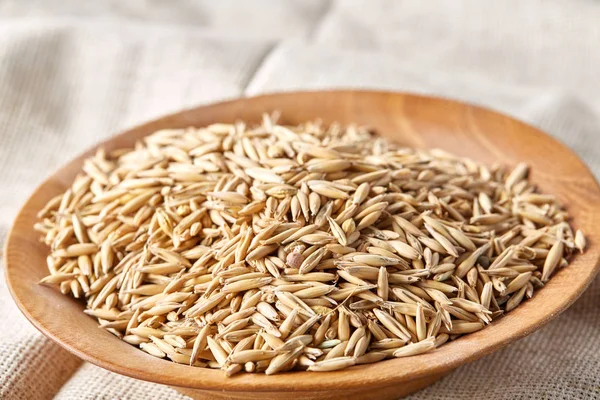 Yulaf kabuğu çıkarılmış tane veya yulaf ani artış ahşap plaka saf masa örtüsü, kopya alanı, üstten görünüm seçici odak üzerinde