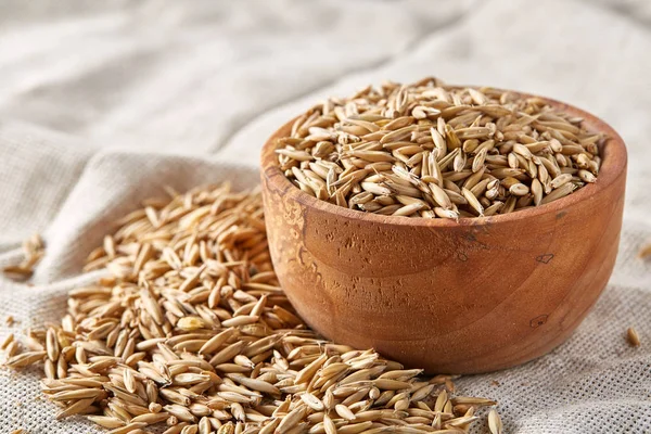 Yulaf kabuğu çıkarılmış tane veya yulaf ani artış ahşap plaka saf masa örtüsü, kopya alanı, üstten görünüm seçici odak üzerinde