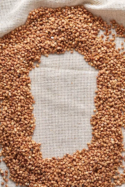 Karabuğday kabuğu çıkarılmış tane çuval bezi arka plan, üstten görünüm, yakın çekim, seçici odak, sığ derinlik-in tarla, dikey.