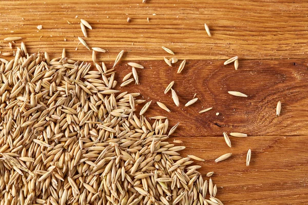 Soyulmamış yulaf taneleri saf masa örtüsü arka plan, üstten görünüm, yakın çekim, makro, seçici odak yığını.