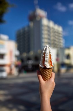Bir ilk kişi görünümü, kız bir dondurma sığ derinlik-in tarla onun elinde olan yol boyunca yürüyüş.