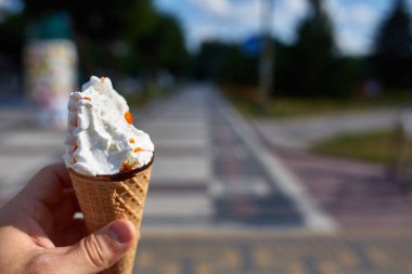 İlk kişi görüntüleyebilir, bir kişi bir dondurma sığ derinlik-in tarla onun elinde olan yol boyunca yürüyüş.