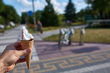 İlk kişi görüntüleyebilir, bir kişi bir dondurma sığ derinlik-in tarla onun elinde olan yol boyunca yürüyüş.