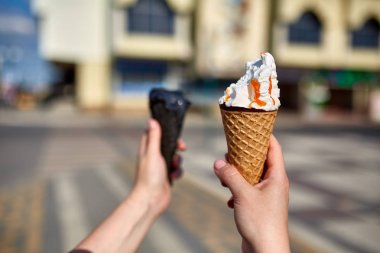 Bir ilk kişi görünümü, kız bir dondurma sığ derinlik-in tarla onun elinde olan yol boyunca yürüyüş.