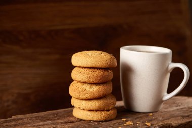 Ahşap ahşap arka plan, üstten görünüm, seçici odak parçası üzerinde çay ve tatlı kurabiye beyaz porselen kupa
