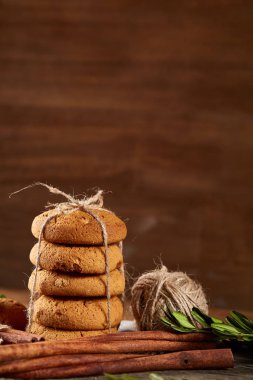 Tanımlama bilgileri, tarçın ve hafif ahşap arka plan üzerinde kurutulmuş portakal yığını ile Noel kompozisyon yakın çekim.