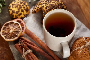 Bir fincan sıcak çay, kurabiye ve dekorasyon ahşap arka plan, seçici odak üzerinde bir oturum ile Noel kavramı