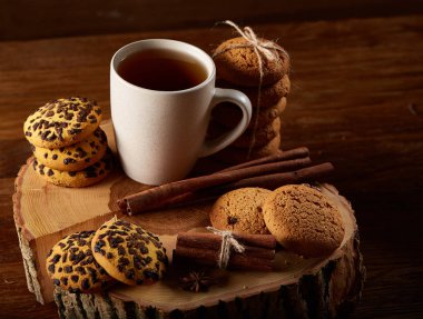 Bir fincan sıcak çay, kurabiye ve dekorasyon ahşap arka plan, seçici odak üzerinde bir oturum ile Noel kavramı