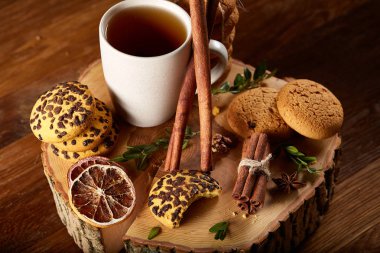 Bir fincan sıcak çay, kurabiye ve dekorasyon ahşap arka plan, seçici odak üzerinde bir oturum ile Noel kavramı