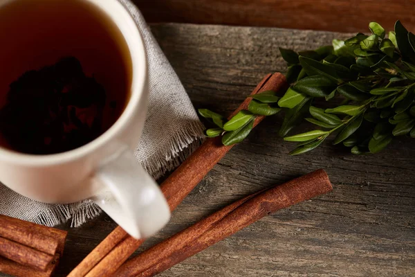 Concepto tradicional de té de Navidad con una taza de té caliente, galletas y decoraciones en una mesa de madera, enfoque selectivo —  Fotos de Stock