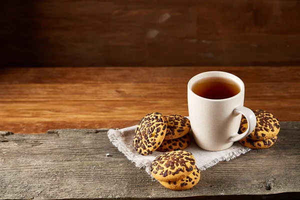 Fincan çay ve Çikolata parçalı kurabiye ülke tarzı, seçici odak beyaz saf peçete üzerinde.