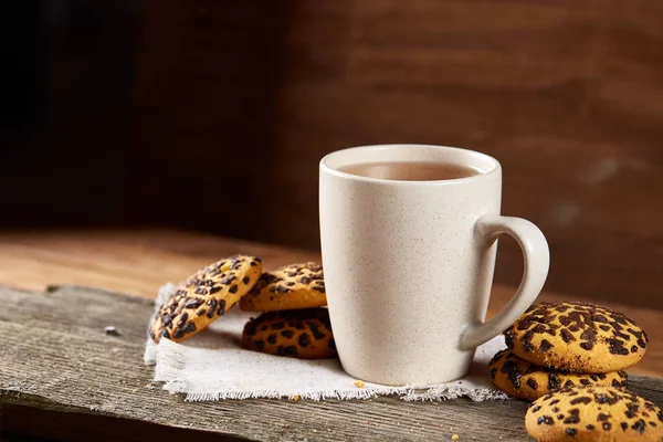 Fincan çay ve Çikolata parçalı kurabiye ülke tarzı, seçici odak beyaz saf peçete üzerinde.