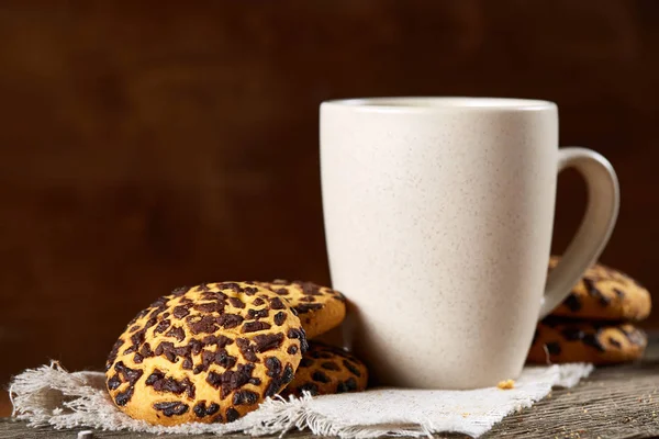 Fincan çay ve Çikolata parçalı kurabiye ülke tarzı, seçici odak beyaz saf peçete üzerinde.