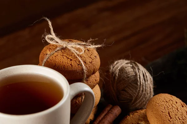 Bir fincan sıcak çay, kurabiye ve dekorasyon ahşap arka plan, seçici odak üzerinde bir oturum ile Noel kavramı