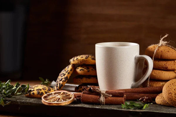 Bir fincan sıcak çay, kurabiye ve dekorasyon ahşap arka plan, seçici odak üzerinde bir oturum ile Noel kavramı