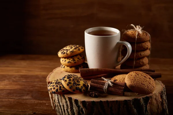 Concetto natalizio con una tazza di tè caldo, biscotti e decorazioni su uno sfondo di legno, messa a fuoco selettiva — Foto Stock