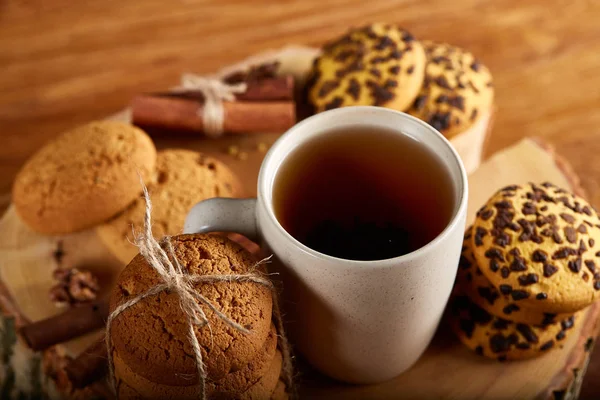 Bir fincan sıcak çay, kurabiye ve dekorasyon ahşap arka plan, seçici odak üzerinde bir oturum ile Noel kavramı